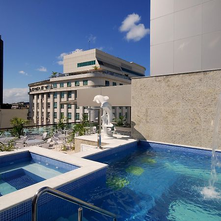 Hotel Atlantico Business Centro Rio de Janeiro Buitenkant foto The photo shows a rooftop area featuring a swimming pool and a spa. The pool is inviting with a clear blue water, and there appears to be a waterfall feature. Surrounding the pool are areas for relaxation, possibly with sun loungers. In the backgroun